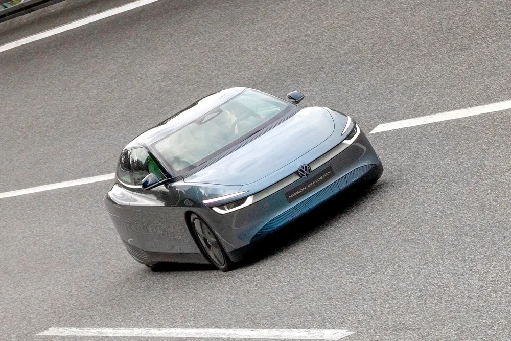 Voiture électrique Volkswagen roulant sur une autoroute, design futuriste et aérodynamique.