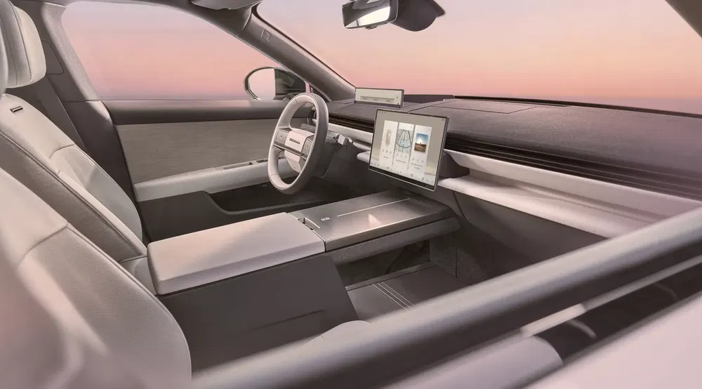 Intérieur moderne et minimaliste d'une voiture électrique avec écran tactile central large.