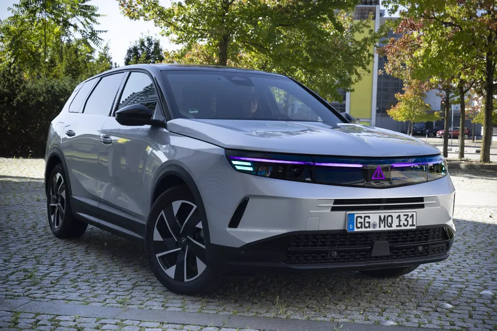 Moderne elektrische Opel SUV met stijlvol design en opvallende LED-verlichting op geplaveide weg.