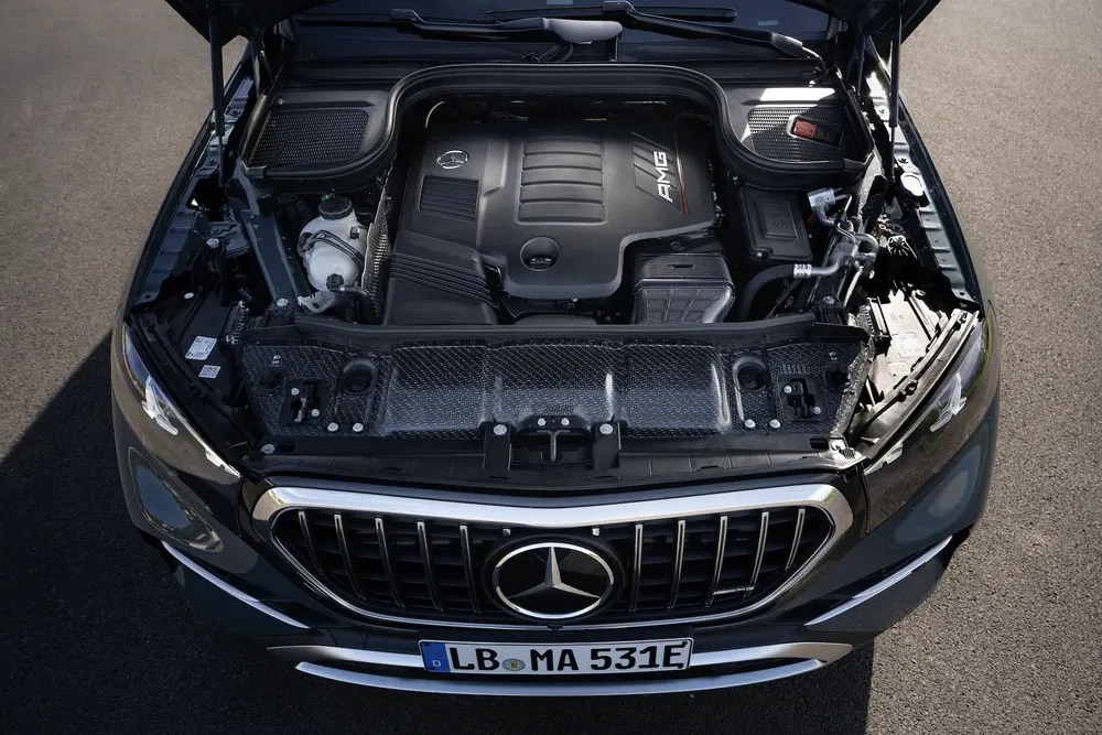 AMG-motor in de motorkap van een Mercedes-Benz met zichtbare nummerplaat.