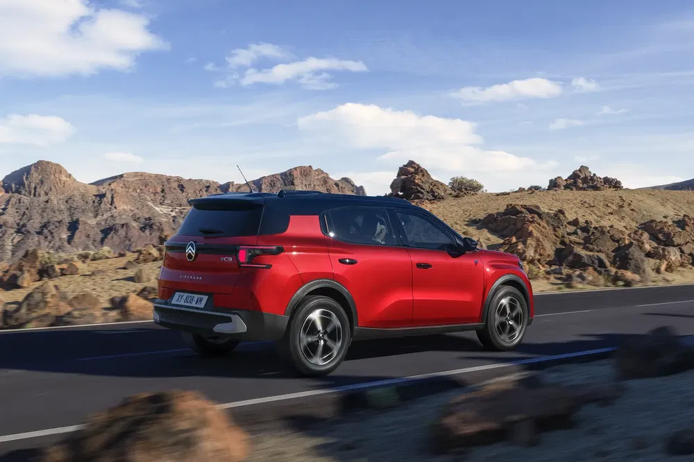Rode Citroën C5 Aircross rijdt op een weg omgeven door rotsachtige landschappen.
