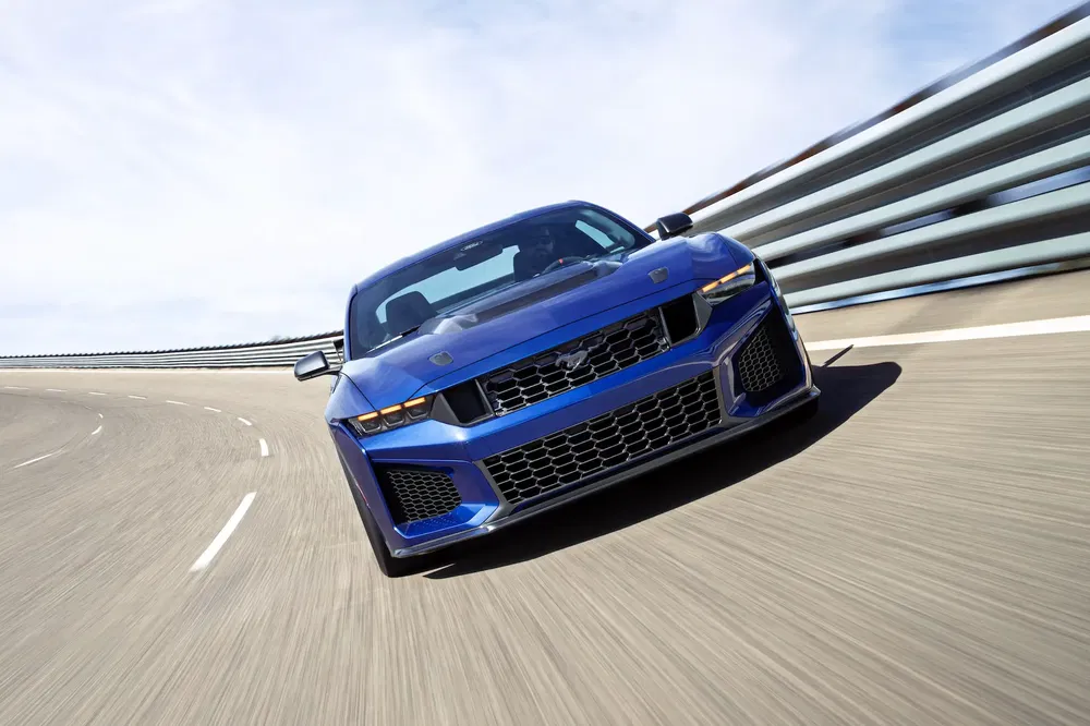 {"fr":"Voiture sportive bleue sur piste, design aérodynamique avec calandre distinctive.","nl":"Blauwe sportwagen op circuit, aerodynamisch ontwerp met kenmerkende grille."}