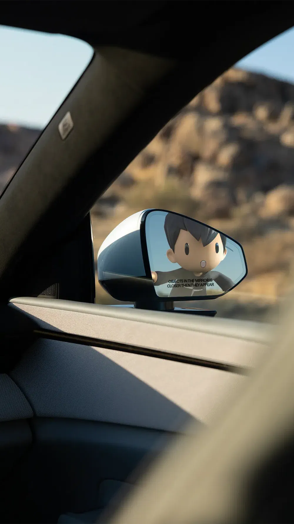 Interieur van auto met tekenfilmfiguur gereflecteerd in de zijspiegel.