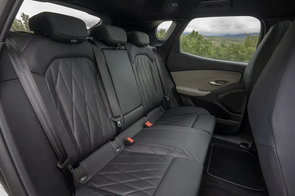Intérieur en cuir noir d'un SUV moderne avec sièges arrière luxueux et ceintures de sécurité.
