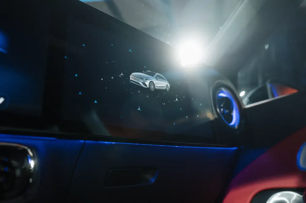 Autodisplay met digitale afbeelding van moderne auto in verlicht interieur.