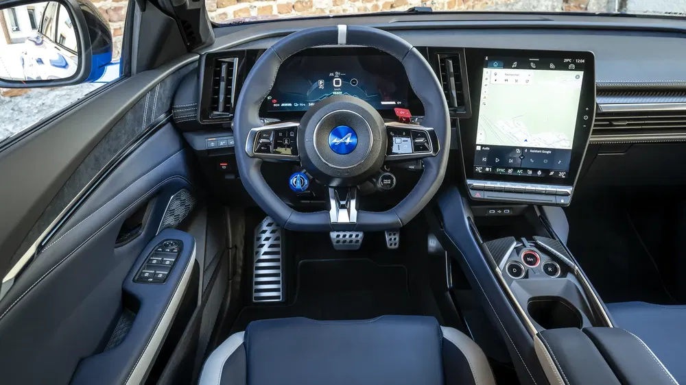 Intérieur de l'Alpine A110 R, volant sport et écran tactile moderne.