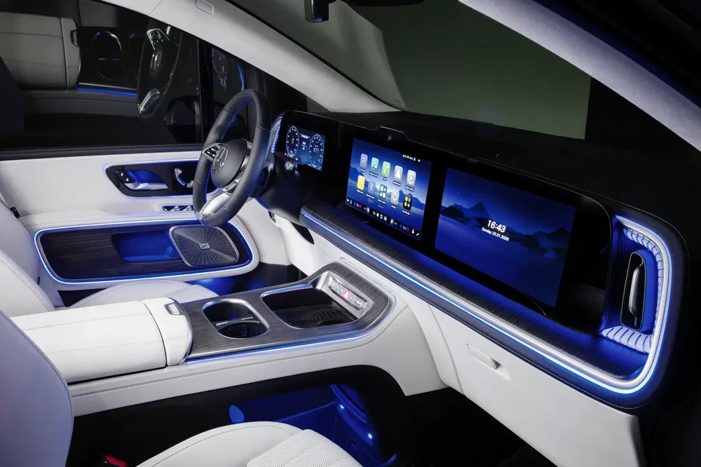 Luxe interieur van een Mercedes EQS, blauwe sfeerverlichting, moderne touchscreen display.