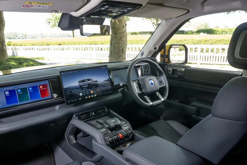 Moderne SUV-interieur met multifunctioneel stuurwiel en geïntegreerde digitale touchscreens.