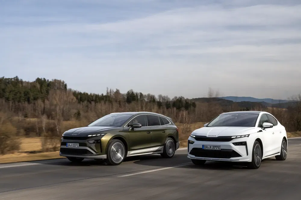 Deux voitures Skoda 2024 roulant sur une route pittoresque, l'une verte et l'autre blanche.