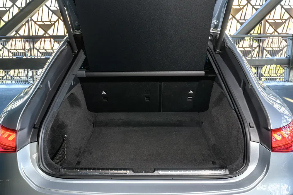 Coffre spacieux d'une voiture berline grise, prêt pour le chargement de bagages.