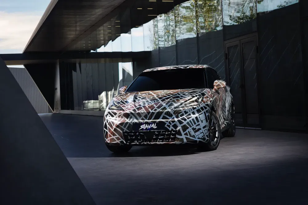 SUV Haval gecamoufleerd, geparkeerd voor een modern gebouw van glas en metaal.