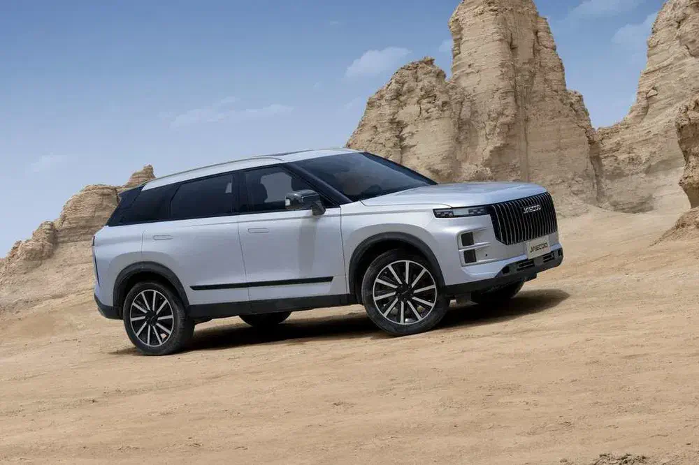 SUV Haval blanc sur terrain désertique avec formations rocheuses en arrière-plan, ciel clair.