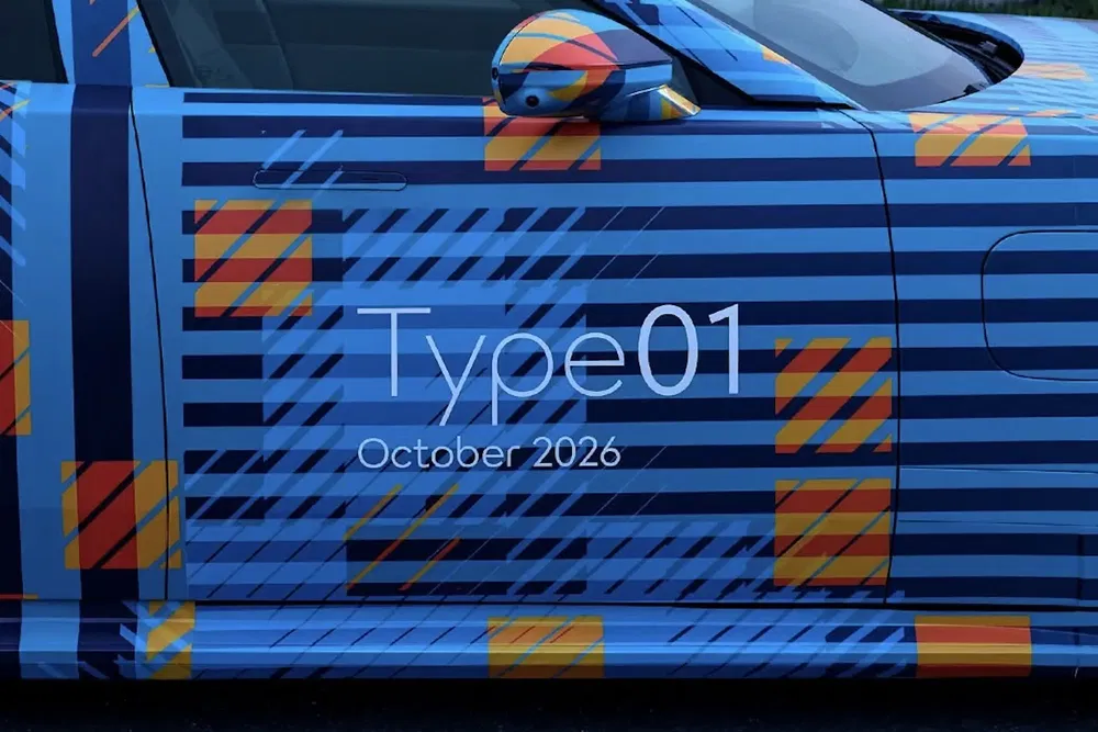 Prototyp van auto Type 01 met blauw en oranje strepen, verwachte lancering oktober 2026.