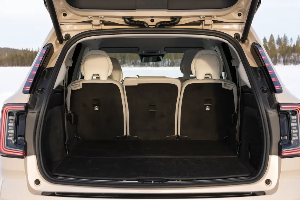 Coffre spacieux du SUV Range Rover Evoque avec sièges rabattables, prêt pour des aventures routières.