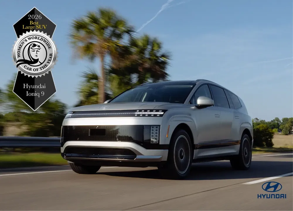 Hyundai Ioniq 9 bekroond 2026, elektrische SUV op weg, palmbomen op achtergrond.