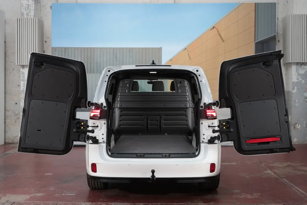 Coffre d'une Peugeot Partner ouverte, prêt pour le chargement, dans un espace industriel.