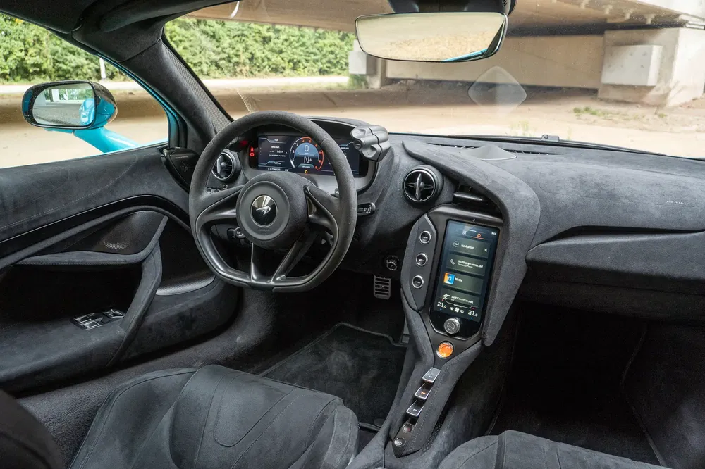 Intérieur luxueux de la McLaren avec tableau de bord moderne et volant distinctif.