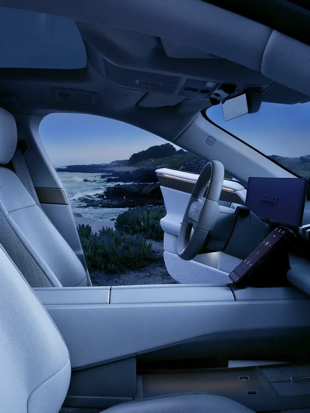 Futuristisch interieur van de Jaguar XK met uitzicht op zee, modern stuur en dashboard.