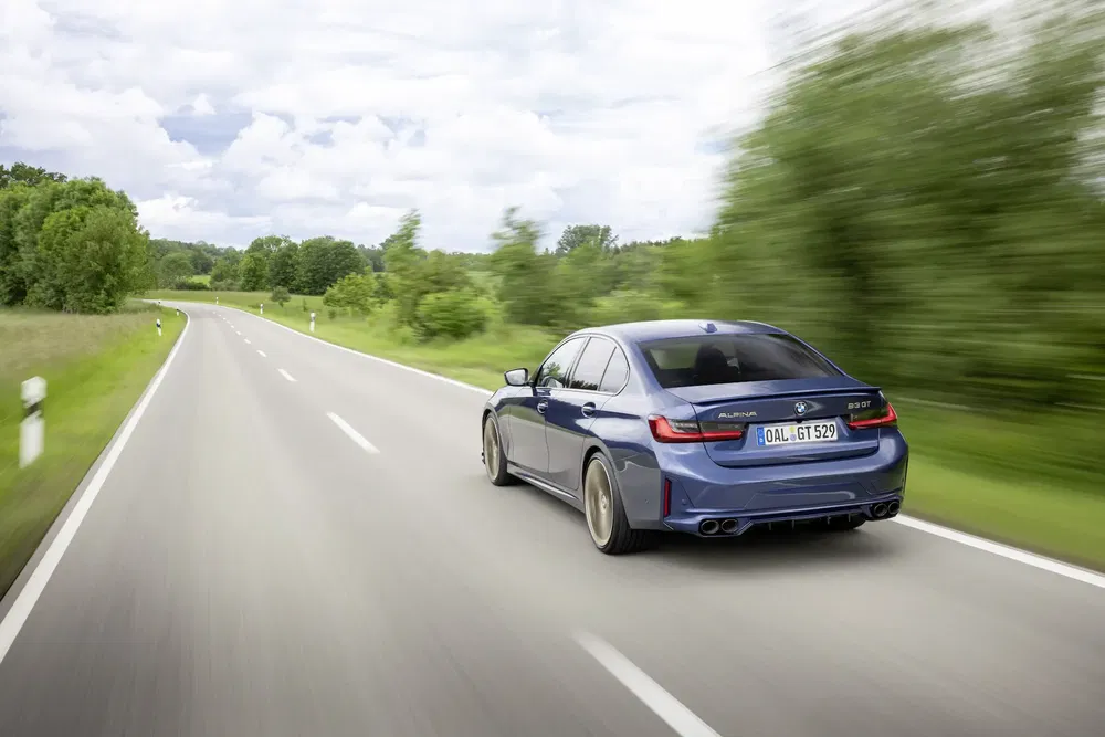 {"fr":"BMW Alpina B5 GT bleu roulant sur une route campagne, ciel nuageux.","nl":"Blauwe BMW Alpina B5 GT rijdt op landelijke weg onder bewolkte hemel."}