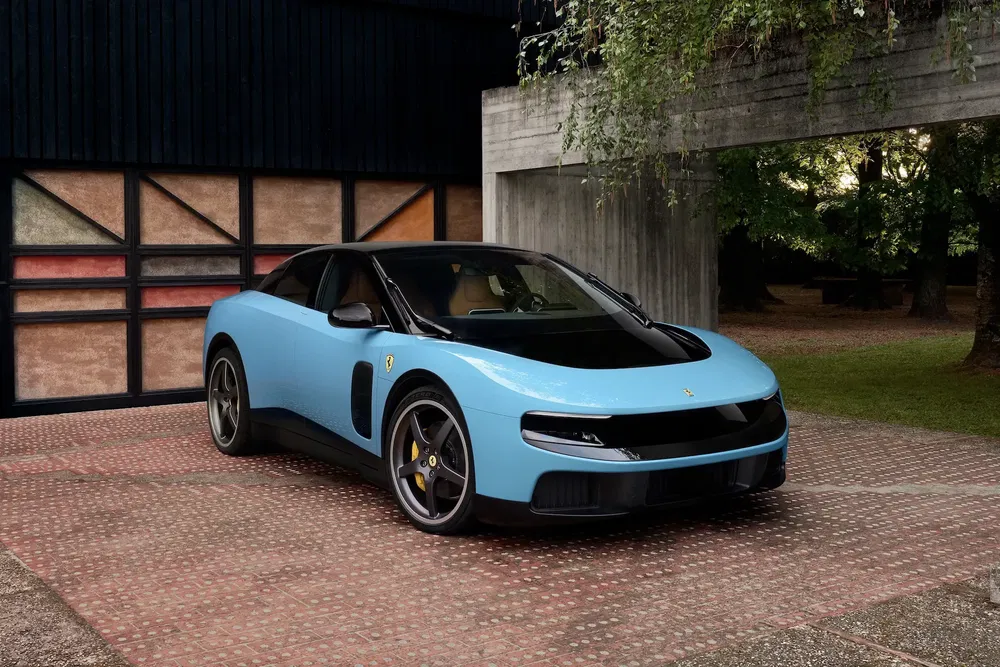 Ferrari moderne bleue garée devant un garage coloré, design sportif et élégant.