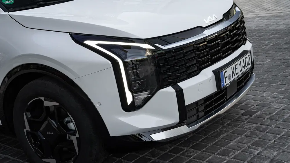 Gros plan sur la calandre distincte du Kia, mettant en valeur ses phares LED modernes et son design.