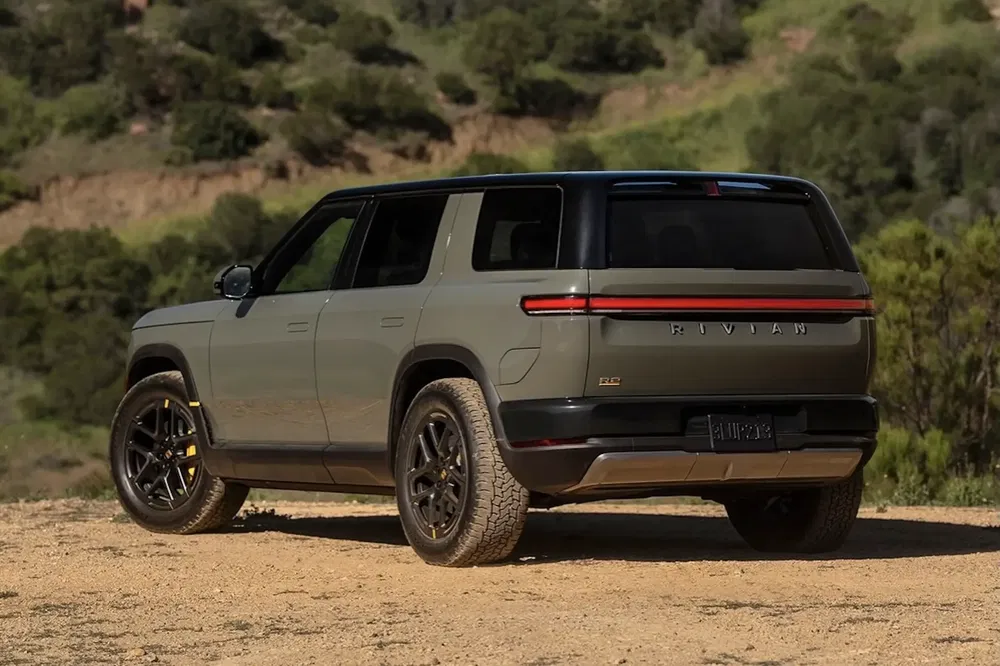 {"fr":"SUV Rivian R1S électrique sur terrain accidenté avec décoration de couleur beige.","nl":"Elektrische Rivian R1S SUV op ruw terrein met beige kleuraccenten."}
