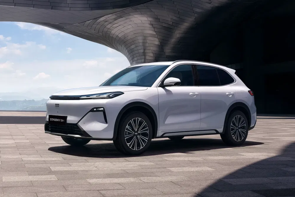 Witte Leapmotor C11 SUV geparkeerd voor een modern gebouw, stijlvol en futuristisch ontwerp.