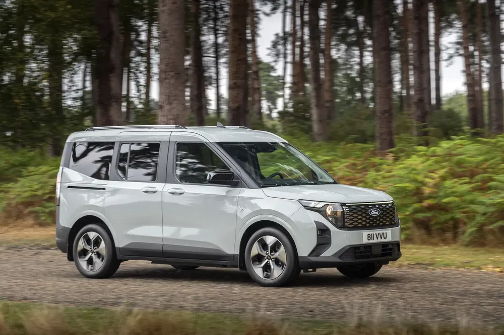 Ford Transit Connect bestelwagen rijdt door bos, perfect voor off-road-avonturen.