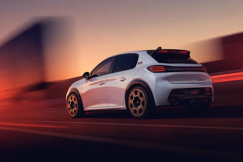 Porsche Macan blanche de nuit, conduite rapide sur une autoroute illuminée.