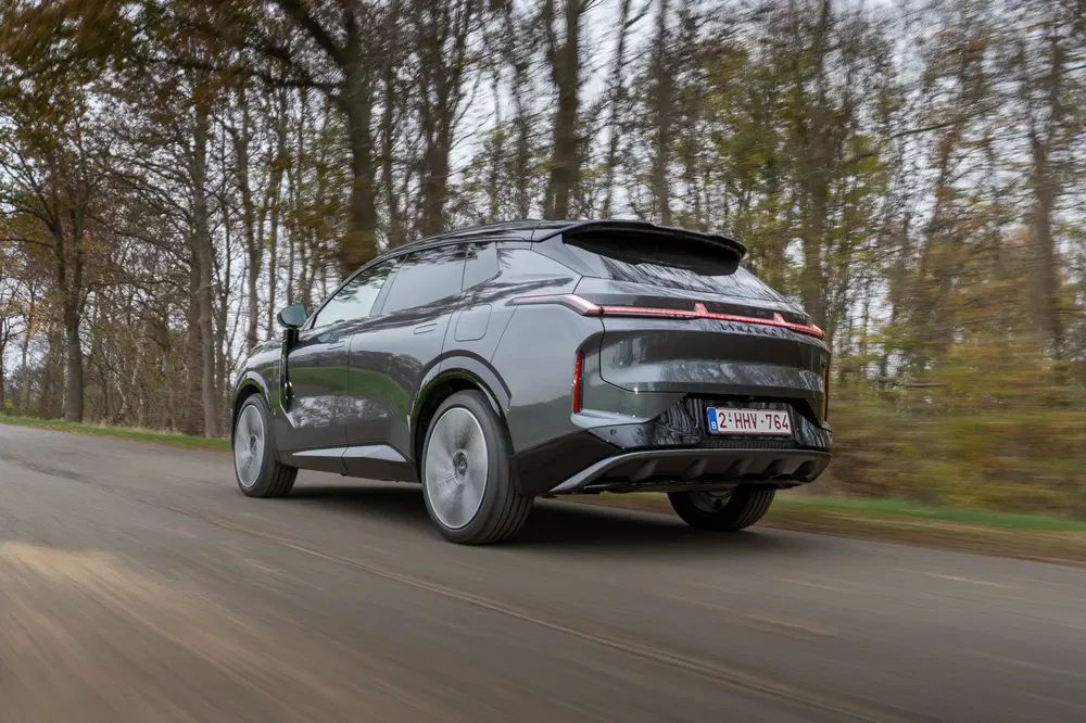 {"fr":"SUV moderne roulant sur une route forestière, arbres en arrière-plan flou.","nl":"Moderne SUV rijdt op een bosweg, bomen vervagen op de achtergrond."}