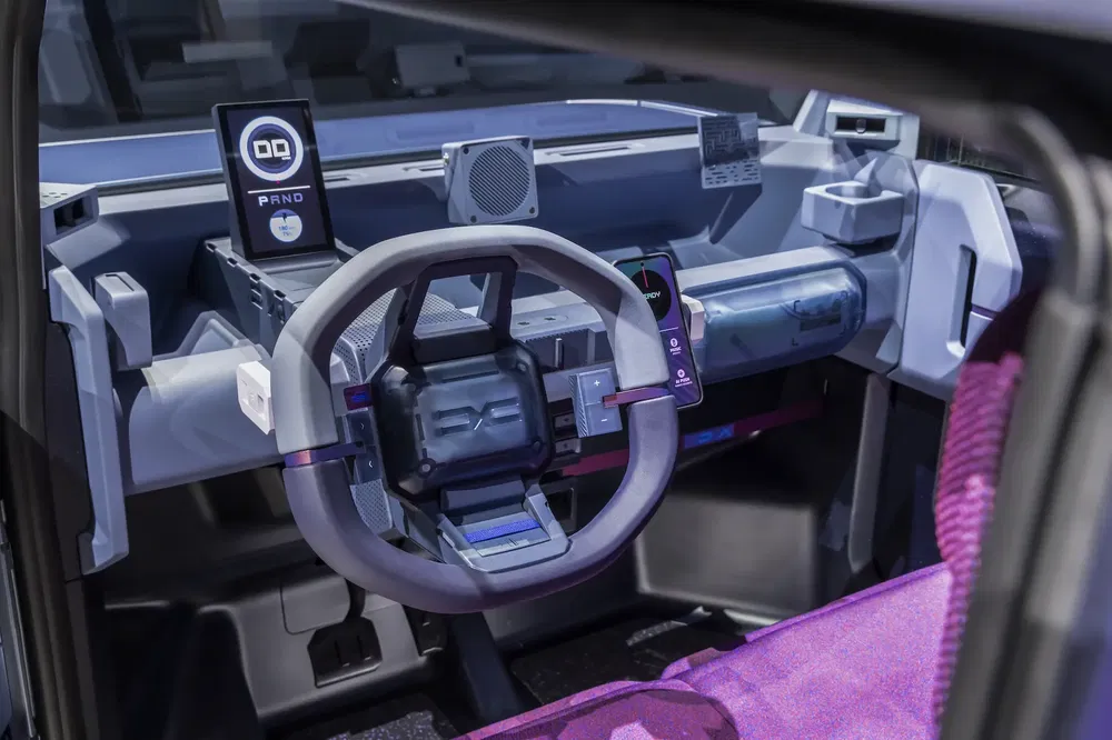 Hoogtechnologisch interieur van een concept elektrische auto met futuristisch stuur en digitale displays.