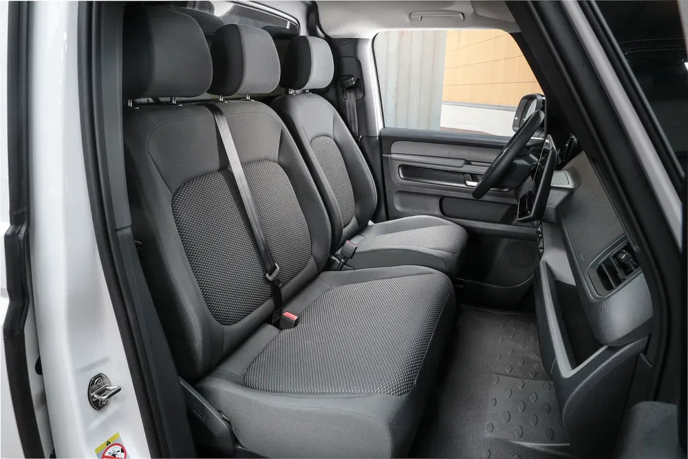 Intérieur des sièges avant de la Citroën Ami, avec des sièges en tissu gris.