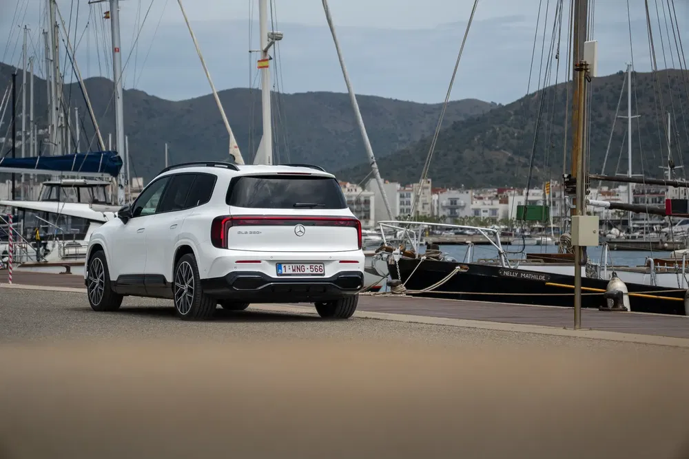 Mercedes-Benz GLB 250 e garé près d'un port de plaisance avec des bateaux en arrière-plan.