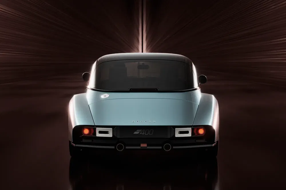 Vue arrière de la Morgan Plus Four, dans un tunnel lumineux futuriste.