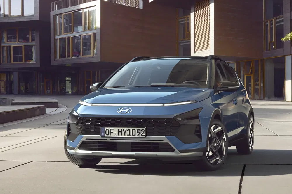 Hyundai Bayon bleu moderne devant bâtiment urbain élégant.