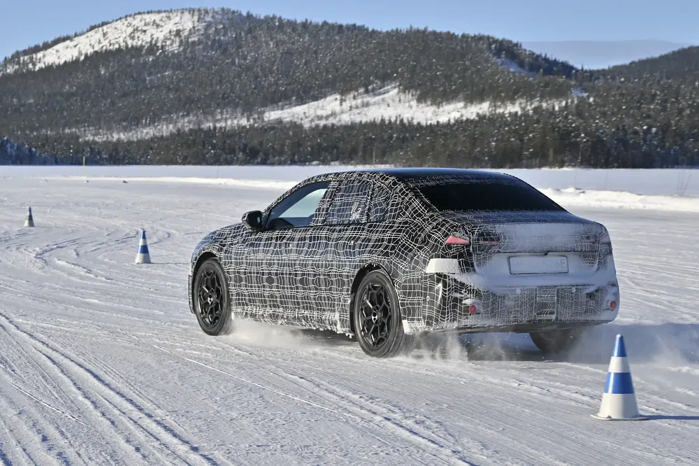 {"fr":"Voiture camouflée testant sur neige, entourée de cônes de signalisation, montagnes en arrière-plan.","nl":"Een gecamoufleerde auto test op sneeuw, omgeven door verkeerskegels, bergen op de achtergrond."}