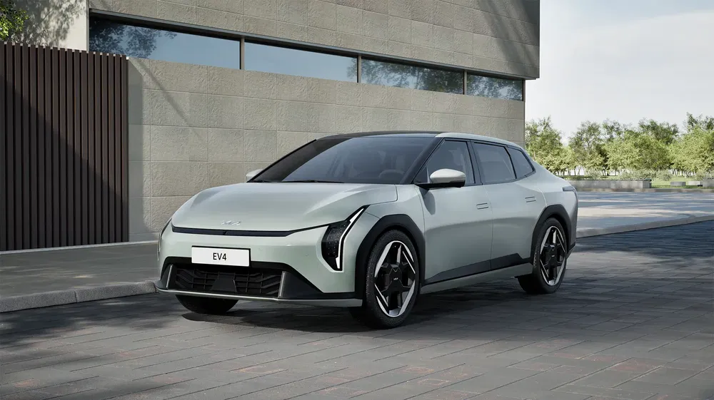 Voiture électrique Hyundai EV4 argentée garée devant un bâtiment moderne.