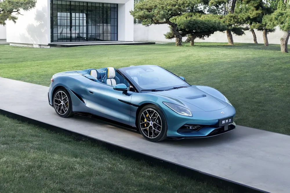 {"fr":"Voiture de sport bicolore moderne sur podium en béton devant maison minimaliste.","nl":"Moderne tweekleurige sportwagen op betonnen podium voor minimalistisch huis."}