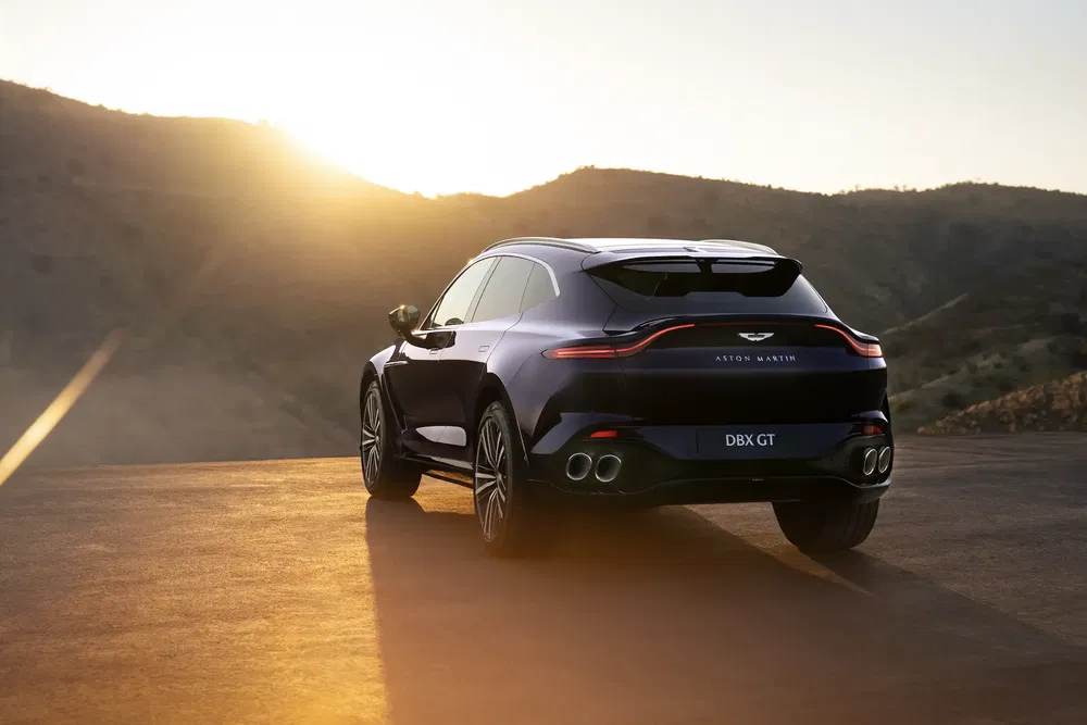 {"fr":"Aston Martin DBX GT en plein air lors d'un coucher de soleil sur des collines.","nl":"Aston Martin DBX GT tijdens zonsondergang, geparkeerd met uitzicht op heuvels."}