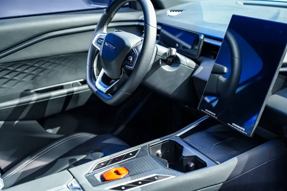 Moderne BYD auto-interieur met opvallend stuurwiel en geïntegreerd centraal touchscreen.