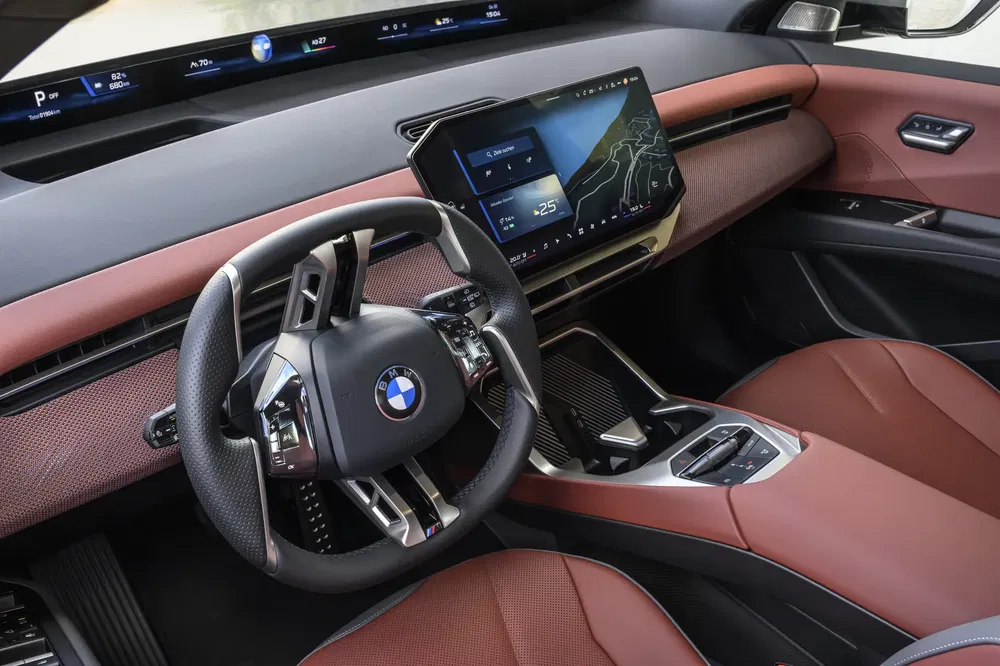 Intérieur luxueux d'une BMW avec tableau de bord numérique moderne et volant ergonomique.