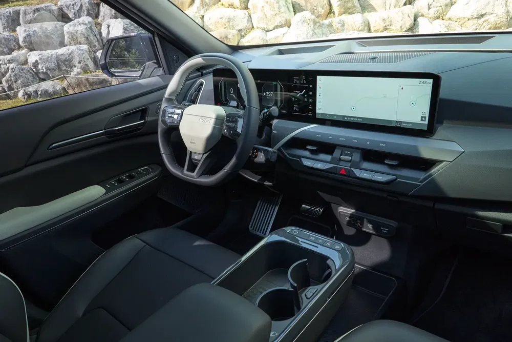 Intérieur moderne de la Kia Sportage avec écran tactile grand format et volant multifonction.