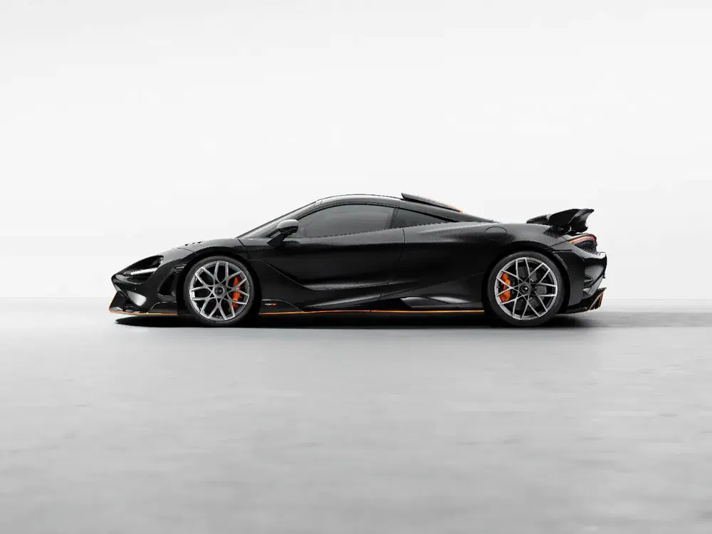 Zijaanzicht van een zwarte McLaren 765LT met achtervleugel tegen een lichte achtergrond.