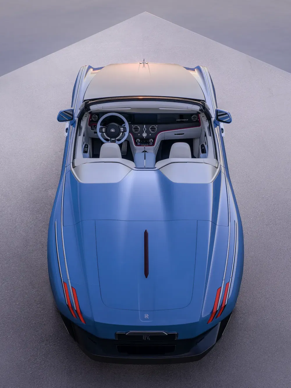 Blauwe Rolls-Royce cabriolet van bovenaf bekeken tegen een grijze achtergrond.