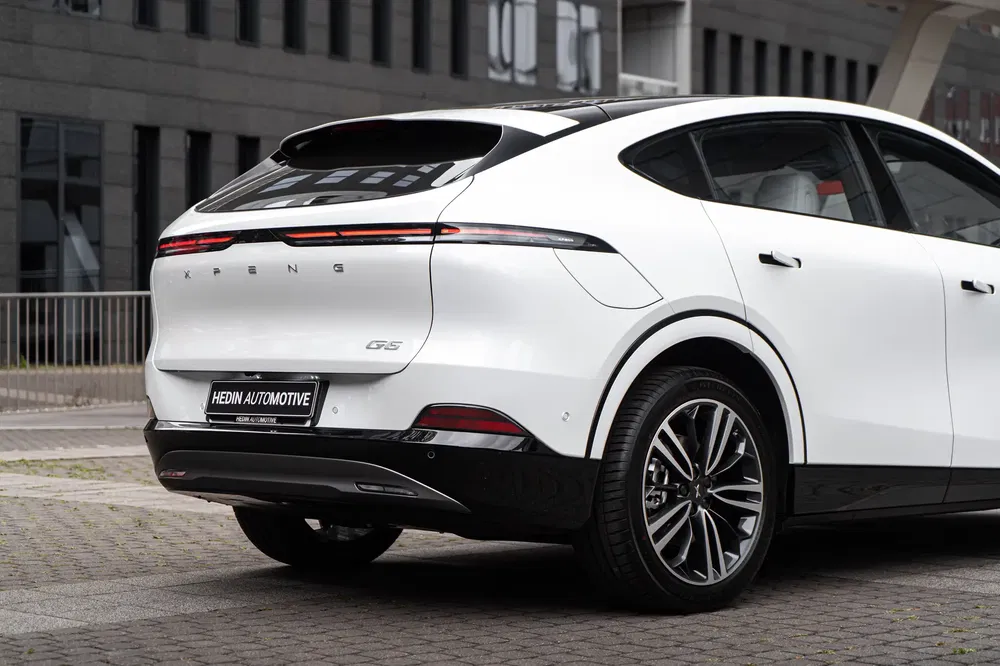 Achterkant van de witte elektrische SUV Xpeng G5, modern ontwerp tegen stedelijke achtergrond.