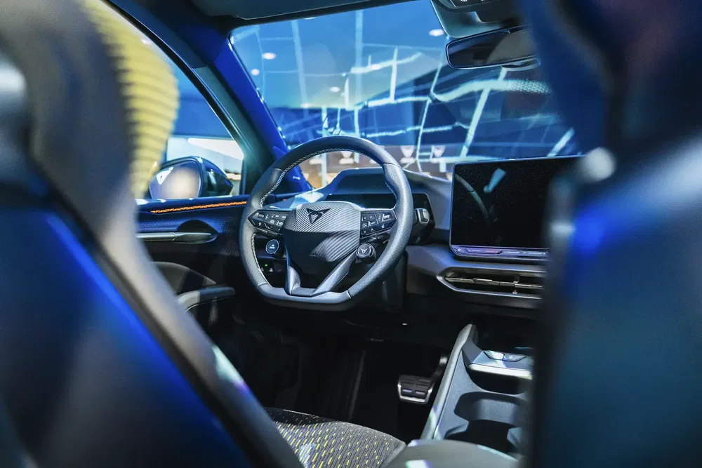 Moderne interieur van een Cupra-auto met touchscreen en futuristisch stuur.