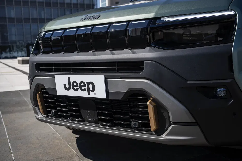 Calandre avant du SUV Jeep moderne, design robuste et élégant en milieu urbain.