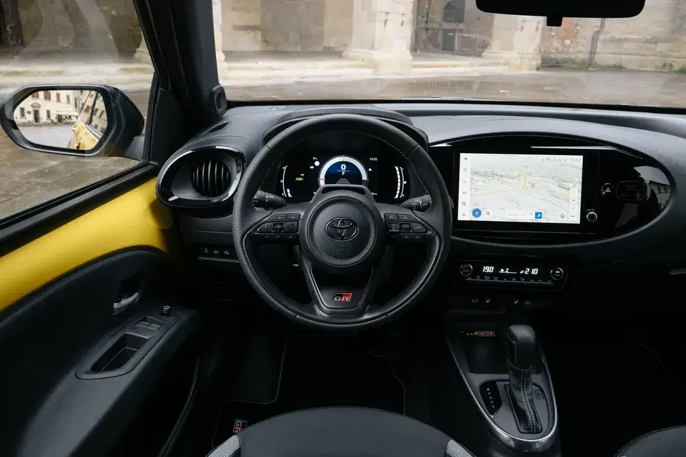 Interieur van de Toyota GR met sportstuur en modern touchscreen display.