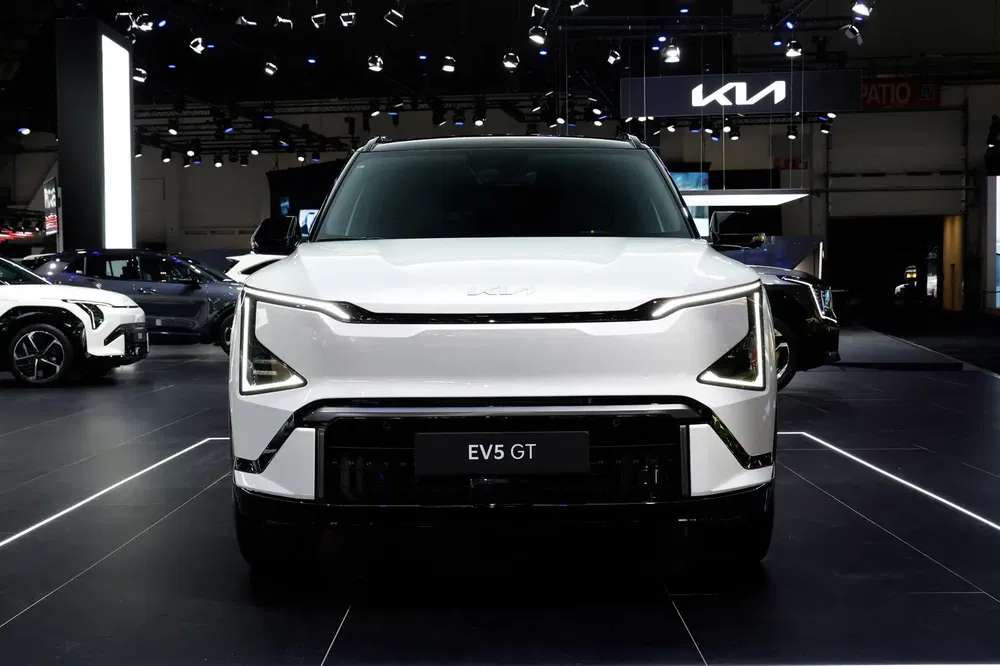 Nouveau modèle Kia EV5 GT blanc exposé avec éclairage de salon auto moderne.