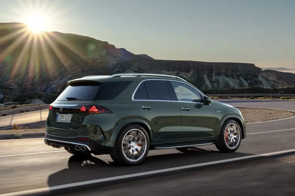 SUV Mercedes-Benz GLE rijdt op een kronkelige weg bij zonsondergang.